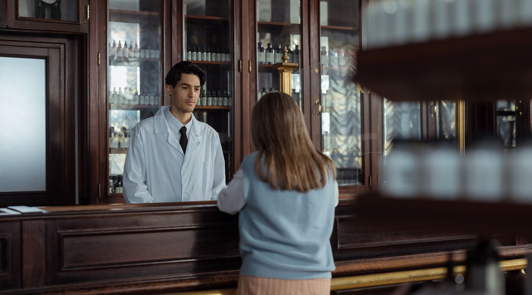 Independent pharmacist assisting a customer at the counter