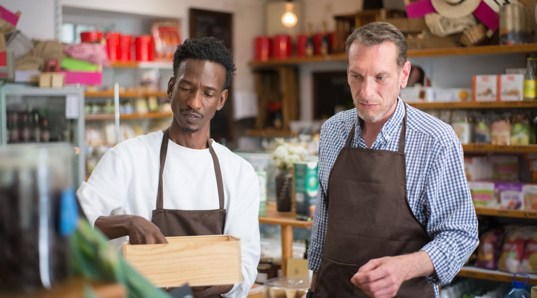 Independent grocery store employees organizing shelf inventory